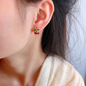 Cute cherry earrings with red fruit and green crystal leaves worn by a model