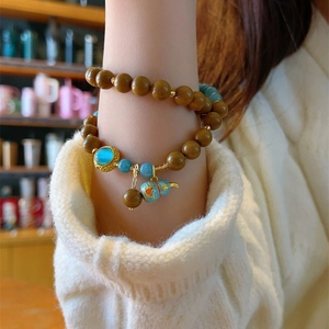 Exquisite beaded bracelet with blue gourd pendant and gemstone charm on model wrist