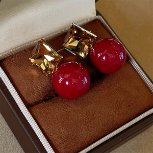 Elegant red square crystal and pearl drop earrings displayed in a luxury jewelry box