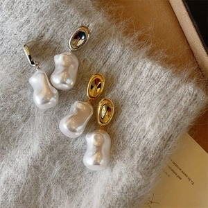 Baroque pearl earrings in gold and silver finish with textured oval metal studs