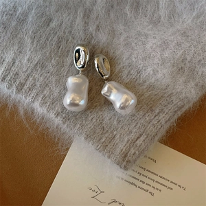 Baroque pearl earrings on a knitted background with a silver finish for a luxury look