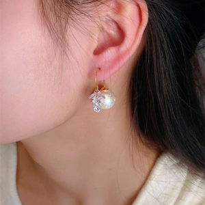 Elegant snowflake pearl drop earrings with zircon tassels and gold-plated hooks on model