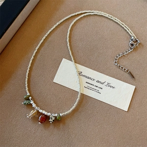 Beaded necklace with Czech beads and natural stone pendants on a textured background