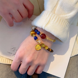Tiger eye and lapis lazuli double-layer beaded bracelet with gold coin pendant on wrist