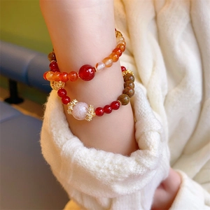 Double-layered beaded bracelet featuring red agate and green stone on a knit sleeve