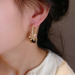 Elegant gold drop earrings with square brown crystal and zircon flower accents on model