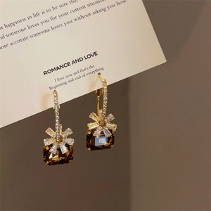 Macro detail of French style earrings with brown square crystal and zircon floral accents
