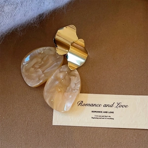 Detaillierte Makroansicht der Vintage-Harz-Ohrringe mit goldenen Metallsteckern