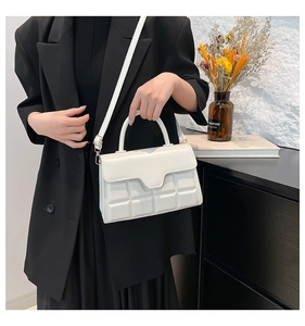 Detailansicht der weißen Handtasche mit Schokoladen-Karomuster und elegantem Tragegriff