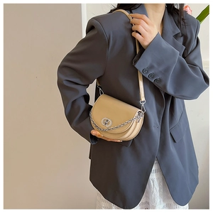 Detail of minimalist khaki crescent bag with silver chain and metal twist lock