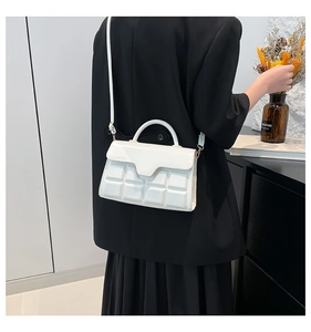 Detailansicht der weißen Lederhandtasche mit geometrischer Prägung und Schultergurt