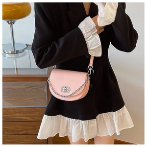 Pink PU leather half-moon saddle bag with silver chain and metal lock on a model