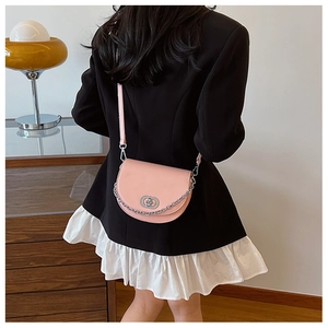 Close-up of pink crescent saddle bag featuring silver chain and metal twist lock