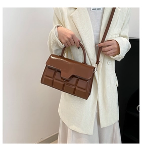 Detail der braunen Schokoladen-Prägestruktur und der glänzenden Oberfläche der Handtasche
