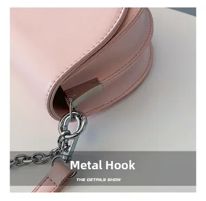 Detail of pink leather bag showing silver metal chain strap with lobster claw hook