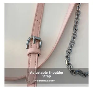 Detail of pink PU leather shoulder strap with adjustable silver buckle and metal chain