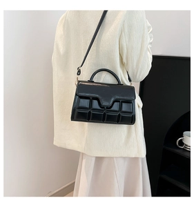 Detail der schwarzen Lackledertasche mit 3D-Prägung und elegantem Griff für Damen