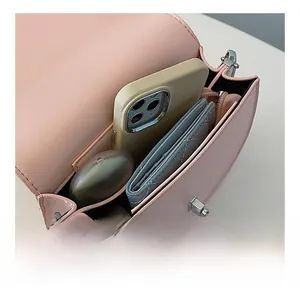 Interior view showing the capacity of a pink leather semi-circle crossbody bag with zipper pocket