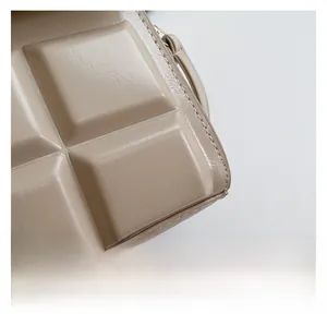 Detailaufnahme der beige Handtasche mit hochwertiger quadratischer Kunstlederprägung