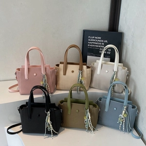 Textured tote bags in six colors with stylish scarves and beaded charms on a white stand