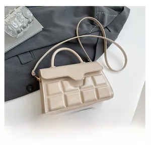 Detailansicht der beigen Handtasche mit quadratischer Prägung und Lederstruktur