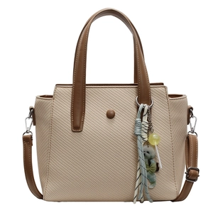 Chic beige woven tote bag with brown handles and a cute bear charm for daily commute