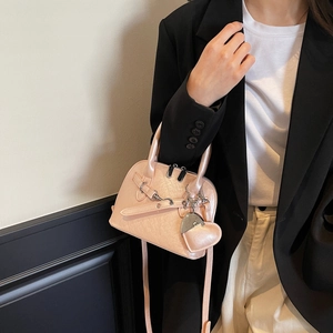 Fashionable peach pink shell bag with pearlescent texture and heart charm