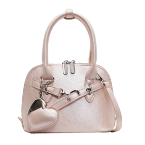Pearlescent pink shell-shaped handbag with silver heart charm and chain in a frontal view