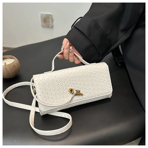 Détail du sac à main en cuir tressé blanc avec un fermoir doré en forme de nœud