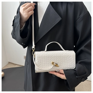 Détail du sac en similicuir tressé blanc avec boucle dorée et bandoulière fine