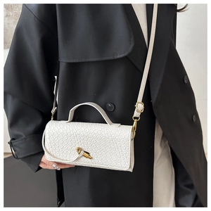 Détail de la texture en cuir tressé blanc avec un fermoir doré élégant sur le sac à rabat