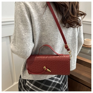 Détail du sac à main en cuir tressé rouge avec fermoir rotatif en nœud doré élégant