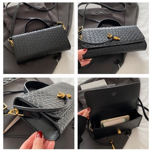 Détail du sac bandoulière en cuir tressé noir avec fermoir doré et rangement intérieur