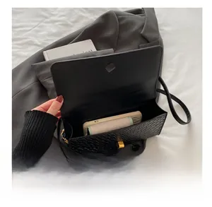 Vue macro de l'intérieur du sac en cuir tressé montrant la capacité et le fermoir doré