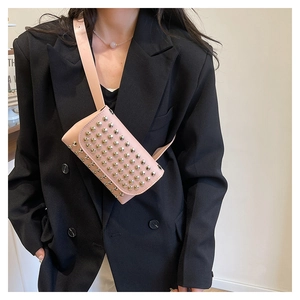 Détail du sac ceinture punk rose avec rivets métalliques et bandoulière en gros plan
