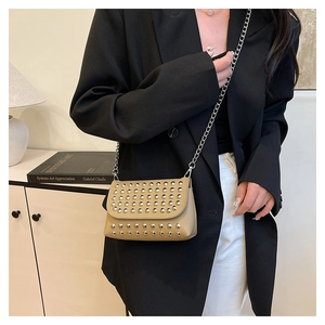 Détail du sac bandoulière punk beige avec rivets argentés et bandoulière chaîne