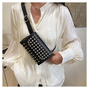 Détail du sac ceinture punk en cuir noir avec clous argentés et bandoulière chaîne