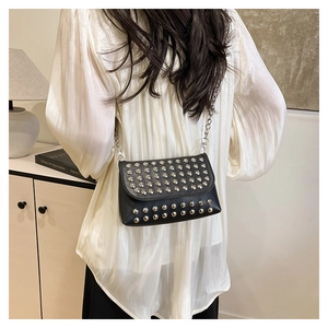 Détail d'un sac ceinture punk noir à rivets et chaîne en métal porté sur le dos