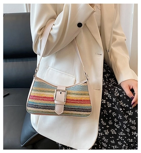 Detail of rainbow straw woven shoulder bag with silver buckle and cream leather trim