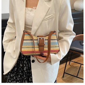 Close-up of bohemian colorful striped straw bag with leather strap and metal buckle detail