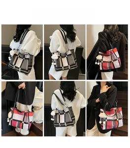 Detail of large plaid tote bag with plush cloud charm and contrast color straps