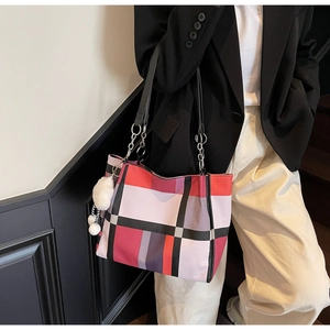 Fashionable large capacity plaid tote bag shown styled on shoulder with plush charm