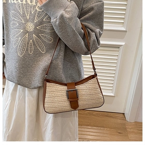 Gros plan du sac à bandoulière en paille et cuir avec boucle et texture tissée neutre