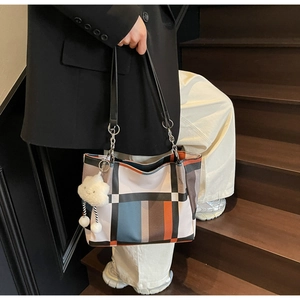 Detail of large tote bag showing colorful plaid pattern and plush cloud pendant charm