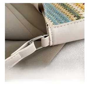Detail of woven straw handbag featuring premium cream leather trim and silver metal ring