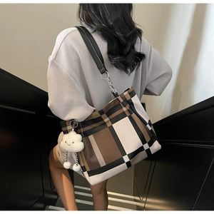 Detail of checkered tote bag featuring leather straps, metal rings and cloud charm