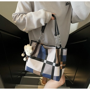Detail of a large checkered tote bag with contrast colors and a plush cloud charm