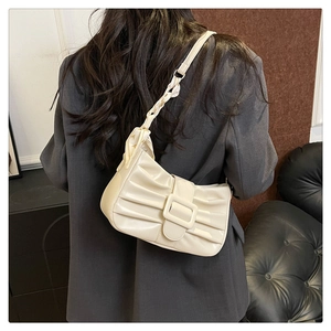 Détail du sac beige plissé avec boucle carrée et bandoulière en foulard de soie
