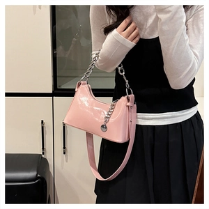 Détail du sac à bandoulière en cuir verni rose avec grosse chaîne argentée et fini brillant