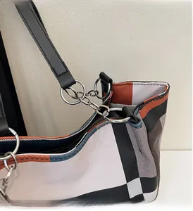 Detail of silver chain link and luxury check pattern on a large fashion tote bag
